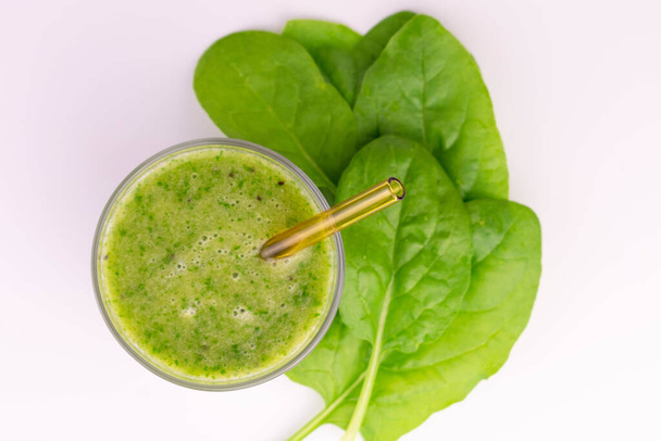 Green smoothie with spinach in a glass on a white background.Lei flat. - Fotó, kép