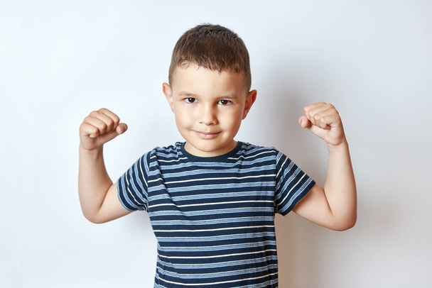 Le beau petit garçon montre les muscles du corps. Antiques pour enfants. - Photo, image