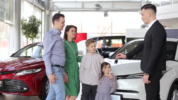 Famille heureuse acheter une nouvelle voiture, concessionnaire de voiture poignée de main avec papa félicité la famille sur une nouvelle voiture, vidéo 4k - Séquence, vidéo
