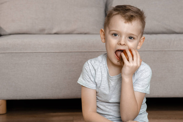 Дети едят здоровую пищу. Смешной ребенок ест яблоко. Маленький симпатичный мальчик с красным яблоком. - Фото, изображение