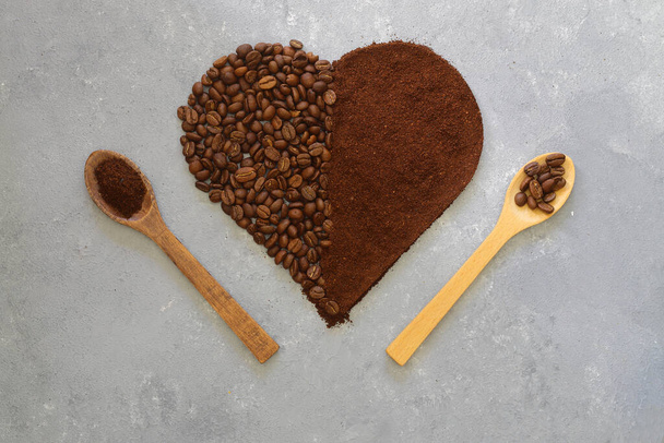Kalp kahvesi. Parlak taş arka planda kalp şeklinde kavrulmuş kahve çekirdekleri. Kahve aşkı kavramı, Sevgililer Günü, iyi ruh hali, hediye. Tahta kaşıkla - Fotoğraf, Görsel