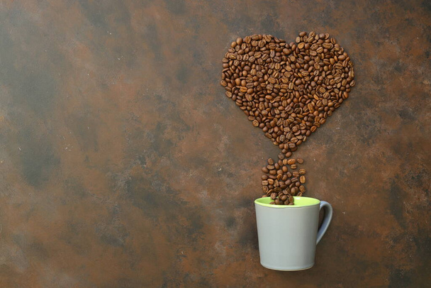 Heart coffee. Roasted coffee beans in the shape of heart on bright stone background. Concept of coffee love, Valentines Day, good mood, gift. With wooden spoon. - Foto, immagini