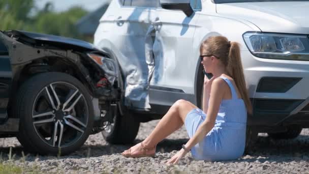 Stressaantunut naiskuljettaja puhuu matkapuhelimella kadulla soittaen hätäkeskukseen auto-onnettomuuden jälkeen. Liikenneturvallisuuden ja vakuutusten käsite. - Materiaali, video