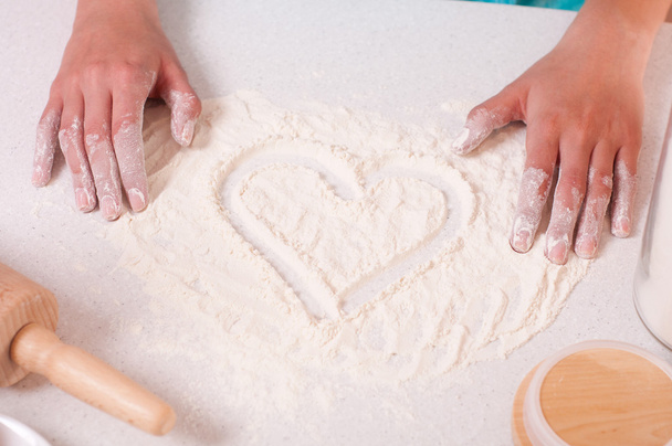 Heart shape on flour, done by woman hands. - Valokuva, kuva