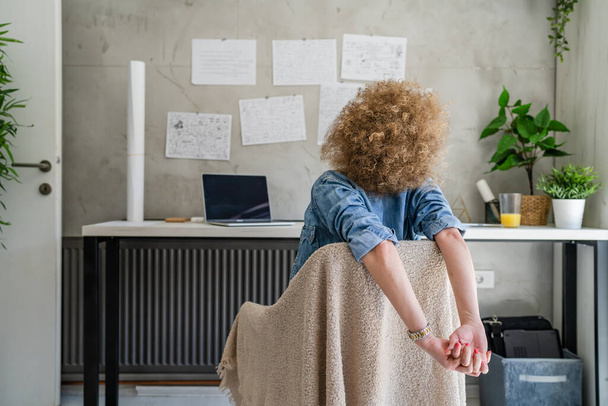 Egy felnőtt nő felnőtt kaukázusi nő az irodájában ül a munkahelyén nyújtózkodó karok Relaxációs gyakorlat Pihenés közben egy fék Munkahely Koncepció másolás tér valós emberek visszapillantás - Fotó, kép