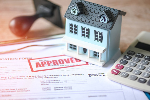 Home loan approved on loan application form paper with rubber stamp calculator and loan house model on table, Loan approval business finance economy commercial real estate investments concept - Photo, Image
