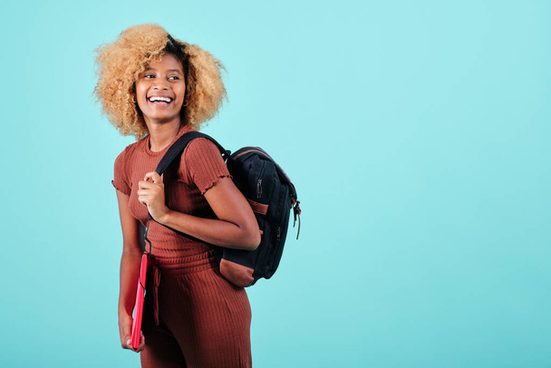 Happy afro student looking away and smiling while standing on an isolated background. Education concept. - Foto, Bild