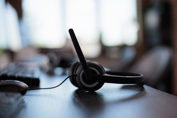 Call center equipment to chat with clients on telephone helpline at helpdesk. Customer service support headphones with microphone for telework and telemarketing assistance. Close up. - Photo, Image