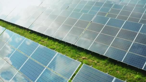 Innovative solar panels produce green energy at electrical station in countryside. Photovoltaic solar modules built on grass on sunny day - Footage, Video