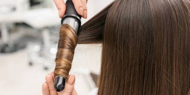 Κομμωτήριο μπούκλες μαλλιά του πελάτη στο σαλόνι ομορφιάς, closeup - Φωτογραφία, εικόνα
