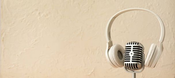 Headphones and retro microphone on light background with space for text - Photo, Image