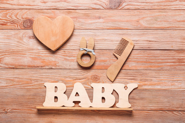 Cabelo pente e palavra BABY no fundo de madeira - Foto, Imagem