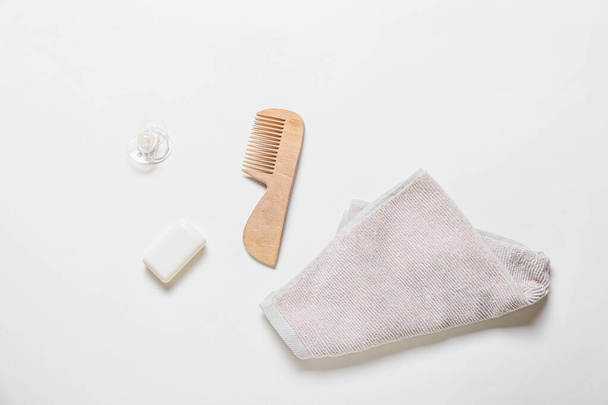 Dřevěný hřeben na vlasy, ručník, bar mýdlo a dudlík na bílém pozadí - Fotografie, Obrázek