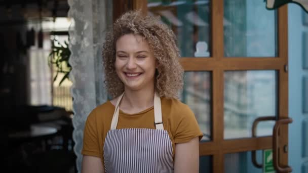 Portret młodej białej kelnerki w piekarni. Nakręcony aparatem hel RED w rozdzielczości 8K.  - Materiał filmowy, wideo