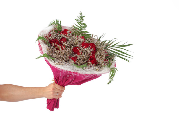 χέρι που κρατά το μπουκέτο από κόκκινα τριαντάφυλλα πάνω από το λευκό φόντο  - Φωτογραφία, εικόνα