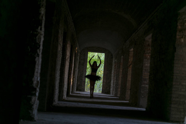 girl with tutu dances in the dark corridor. High quality photo - Foto, Bild