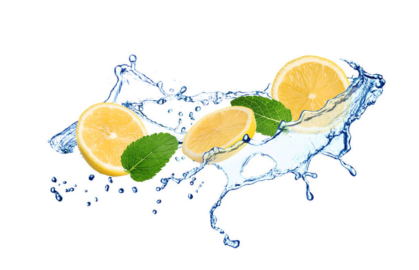 Fresh ripe lemon, mint and splashing water on white background - Photo, image