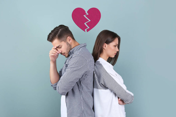 Upset young couple and illustration of broken heart on color background. Relationship problems - Фото, зображення