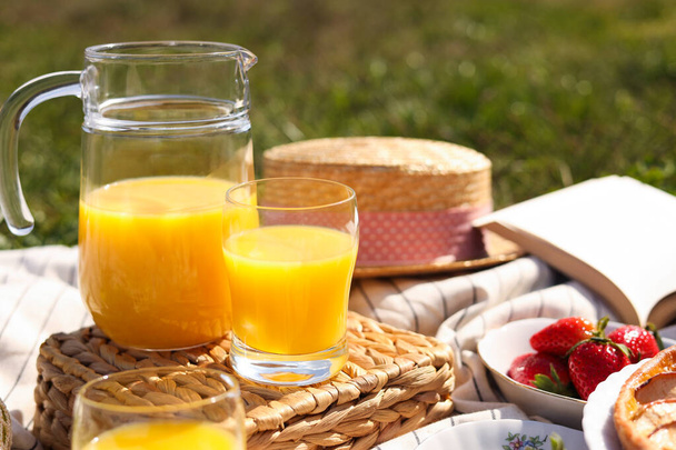 Fresh juice and strawberries on blanket outdoors. Summer picnic - Fotó, kép