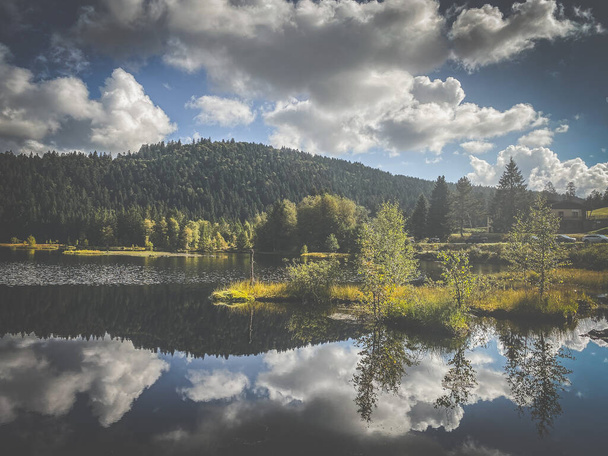 Beautiful clouds reflection in water of Lispach lake in the La Bresse, Vosges - Photo, Image