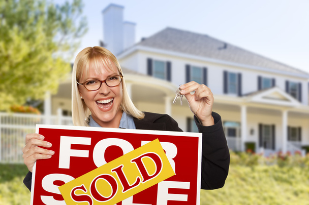 Взволнованная женщина держит ключи от дома и продает табличку о недвижимости
 - Фото, изображение