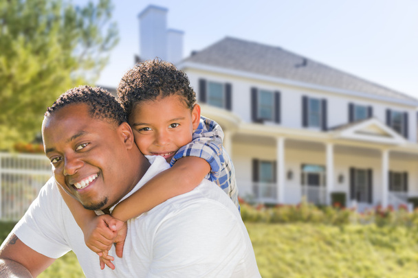 Padre afroamericano e hijo de raza mixta, casa detrás
 - Foto, Imagen