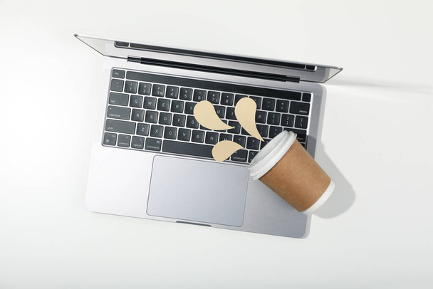 Concept of spilled drink, paper cup and decorative liquid on laptop - Foto, Imagem