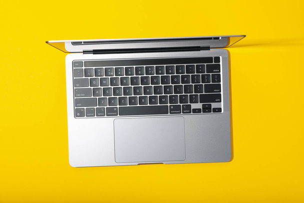 Sarı arkaplanda dizüstü bilgisayar aç, en üst görünümde - Fotoğraf, Görsel