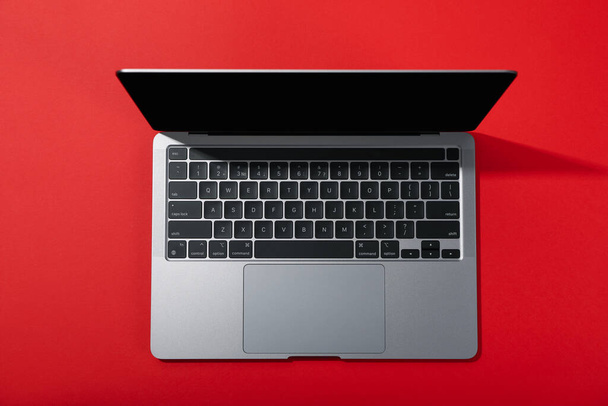 Άνοιγμα φορητού υπολογιστή σε κόκκινο φόντο, κορυφαία προβολή - Φωτογραφία, εικόνα
