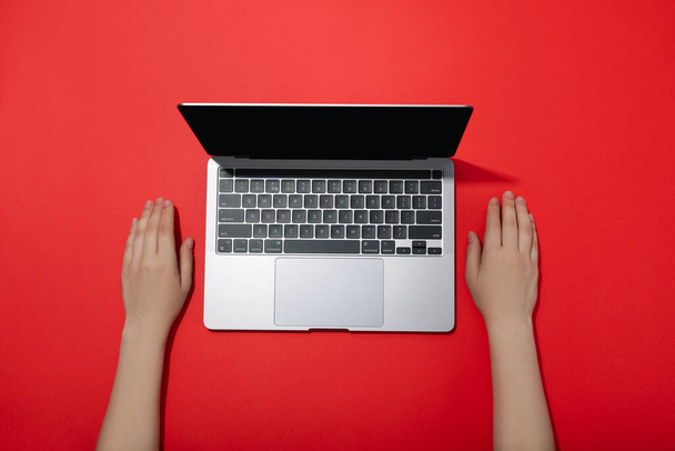 Female hands and laptop on red background - Photo, image