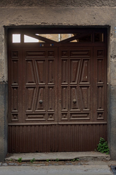 18 〜 19世紀の歴史的な石造りの家の古い磨耗したドア。ヨーロッパの都市への旅行、南イタリア、古いレトロ建築、住宅の建物への正面玄関。木造二重扉 - 写真・画像
