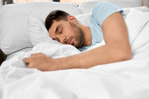concept de personnes, d'heure du coucher et de repos - homme dormant au lit à la maison
 - Photo, image