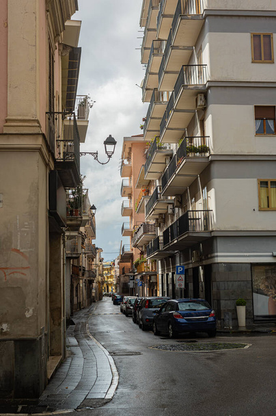 Smalle historische (middeleeuwse) straatjes van een klein stadje in Zuid-Italië. Oude stenen huizen, houten ramen en deuren, geplaveide weg. Europese vakanties, stadswandelingen - Foto, afbeelding