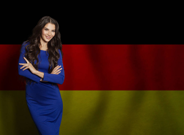 Hermosa mujer morena sonriendo contra el fondo de la bandera alemana - Foto, imagen