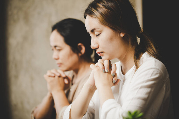  Two women praying worship believe. soft focus, praying and praise together at home. devotional or prayer meeting concept. - Foto, Imagem