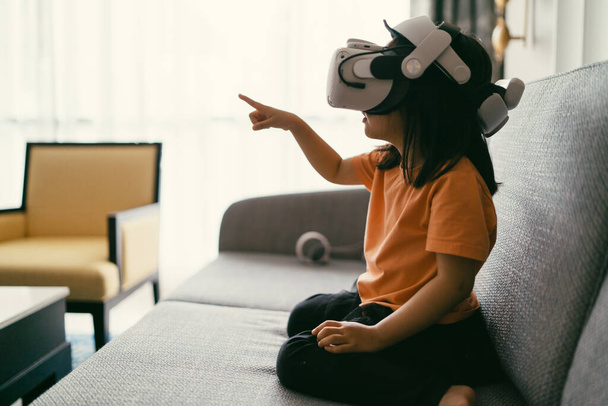Asyalı çocuk kiti sanal gerçeklik ve sanal gerçeklik ile eğlenceli ve heyecan verici olsun, VR kulaklık. Küçük çocuk AR Goggles ile dijital artırılmış gerçeklik teknolojisini keşfediyor.. - Fotoğraf, Görsel