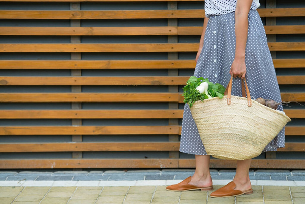 žena drží slámu zpět pro nakupování s výrobky bez plastového obalu. minimalistický koncept - Fotografie, Obrázek
