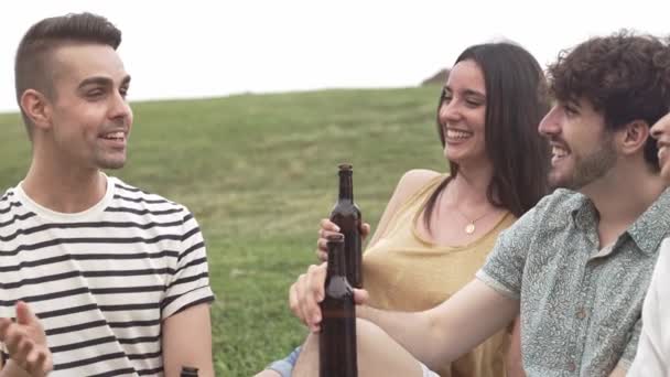 Група молодих щасливих друзів, що сидять на траві, добре розмовляють і сміються влітку
 - Кадри, відео