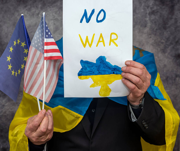 άνθρωπος κρατήσει αφίσα με κείμενο σταματήσει κανένα πόλεμο στην Ουκρανία. Διαδήλωση σε όλο τον κόσμο για τους Σαντιανούς ενάντια στο τρομοκρατικό κράτος της Ρωσίας - Φωτογραφία, εικόνα