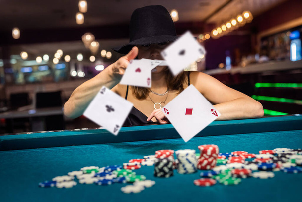 Женщина ищет игральные карты в казино. чипы и деньги, gamblig концепция - Фото, изображение
