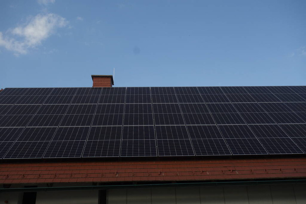 panele słoneczne na dachu domu, wykorzystujące energię odnawialną w nowoczesnych budynkach - Zdjęcie, obraz