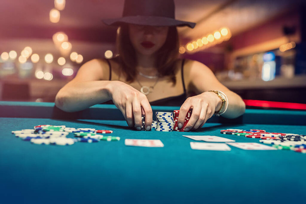 νεαρή γυναίκα με μαύρο φόρεμα κερδίζει στο παιχνίδι Blackjack και χαίρεται με όλες τις μάρκες μετά το παιχνίδι πόκερ, το παιχνίδι έννοια - Φωτογραφία, εικόνα