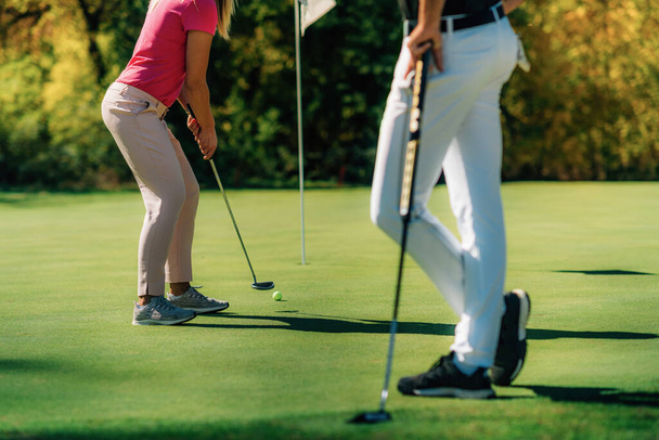 Golf-Paar setzt auf die grünen, unkenntlichen Menschen - Foto, Bild