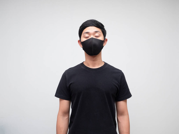 Asian young man black shirt with mask close his eyes feel sleepy on white isolated background - Photo, Image