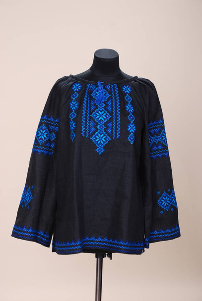 Mavi çiçekli mankenlerin üzerinde siyah kadın gömleği. Vyshyvanka 'nın Ukrayna halk giyiminde güzel mavi bir süs. - Makine nakışı. - Evet. Modern Ukrayna giysileri - Fotoğraf, Görsel