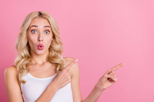 Retrato de atractiva chica rubia alegre demostrando espacio de copia anuncio mirada aislada sobre fondo de color pastel rosa. - Foto, imagen