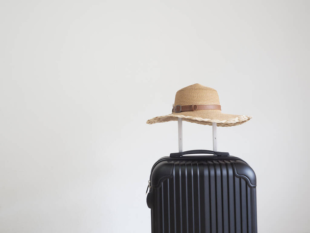 Sombrero vintage por encima del equipaje de color negro en el espacio aislado blanco - Foto, imagen