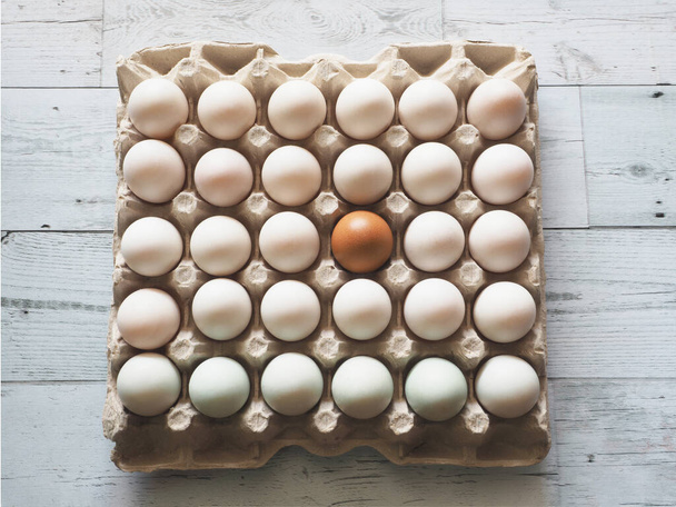 Яйця в качиних яйцях групують в картонній коробці на білому дерев'яному столі ідея різниці та природа світла та тіні вид зверху
 - Фото, зображення
