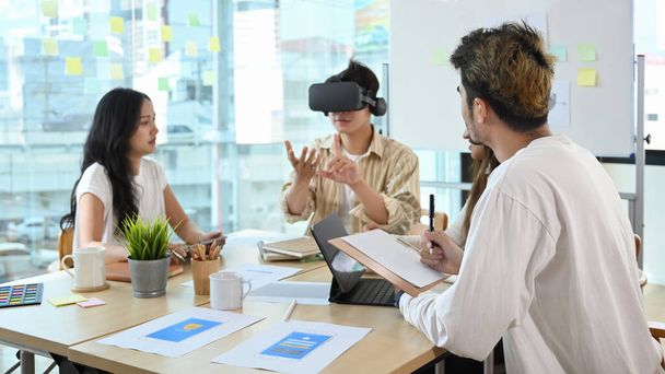 ビジネスミーティングで仮想現実ヘッドセットを身に着けているビジネスマン。チームワーク、スタートアップ、イノベーションコンセプト. - 写真・画像