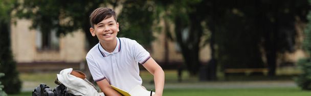 Positive asian schoolboy holding notebook outdoors, banner  - Φωτογραφία, εικόνα